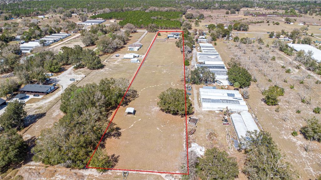An aerial view shows a long, rectangular plot of land outlined in red — 26444 COUNTY ROAD 44A, EUSTIS, FL