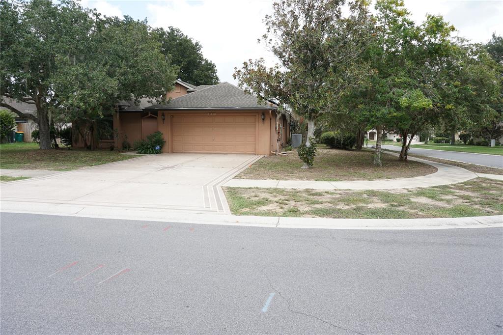 A single-story house with a tan exterior, a two-car garage, and a concrete driveway — 4531 TREASURE CAY ROAD, TAVARES, FL