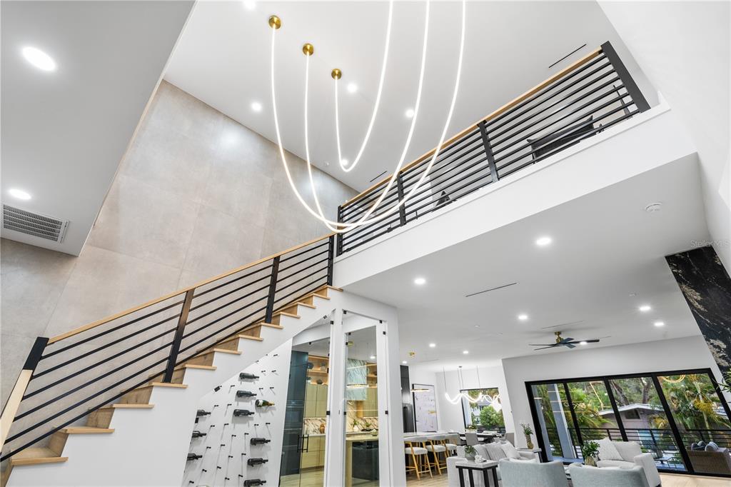 A modern home entrance features a black door, concrete steps, and wood-paneled exterior walls — 4709 W ESTRELLA STREET, TAMPA, FL