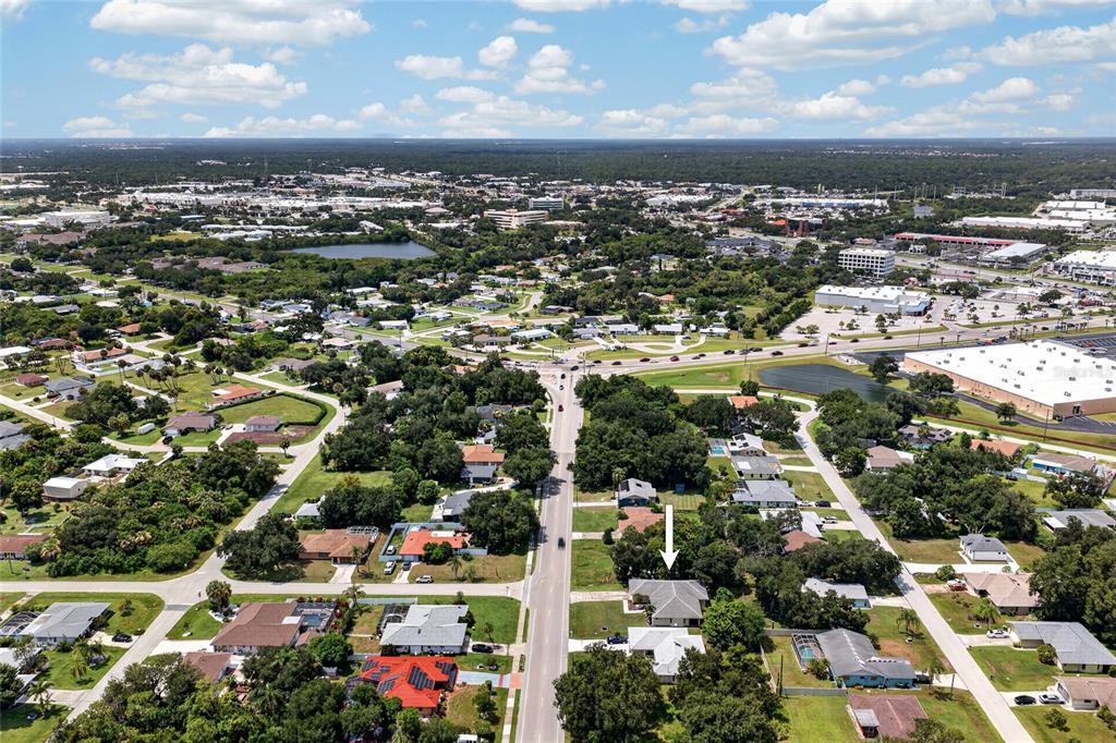 An aerial view shows a residential neighborhood with a white arrow pointing to a house — 2058 LAKE VIEW BOULEVARD, PORT CHARLOTTE, FL