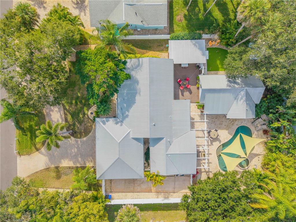 The exterior of a light blue house features a covered porch, brick walkway, and garage — 506 YUPON AVENUE, NEW SMYRNA BEACH, FL