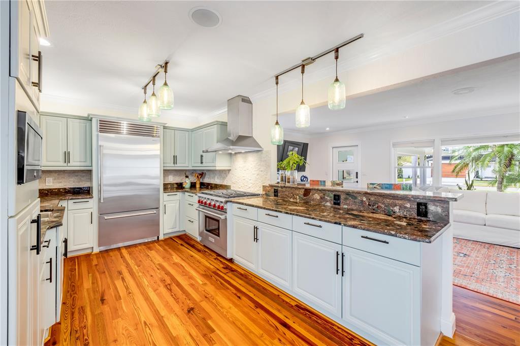 A light blue single-story house with a metal roof and a paved driveway — 506 YUPON AVENUE, NEW SMYRNA BEACH, FL