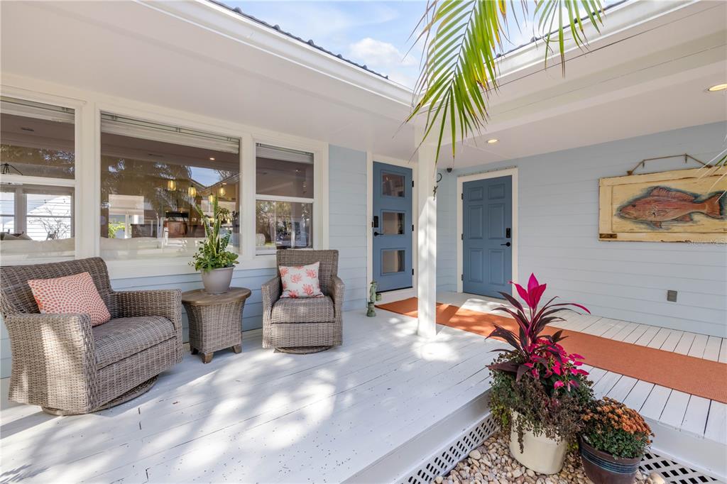 A backyard patio features a swimming pool, hot tub, yellow shade sails, and wicker furniture — 506 YUPON AVENUE, NEW SMYRNA BEACH, FL