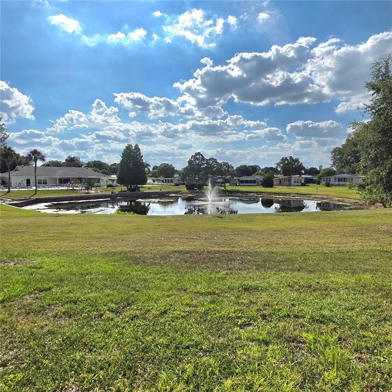 A kitchen with white cabinets, marble-patterned countertops, and a view into an adjacent office space — 6114 GRAND OAKS DRIVE SE, WINTER HAVEN, FL