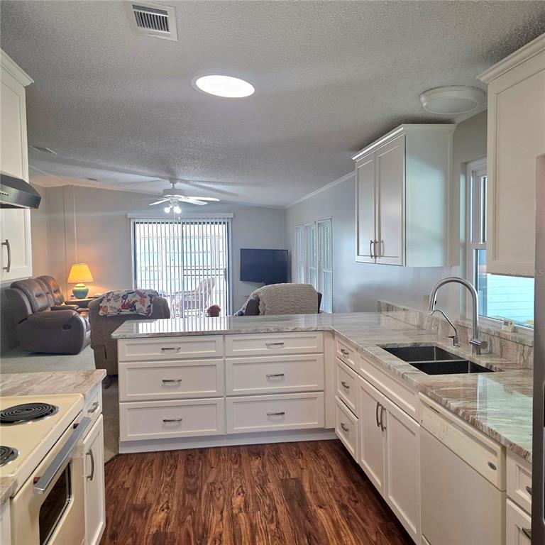 A living room features a beige sofa, a recliner, a coffee table, and a sliding door — 6114 GRAND OAKS DRIVE SE, WINTER HAVEN, FL