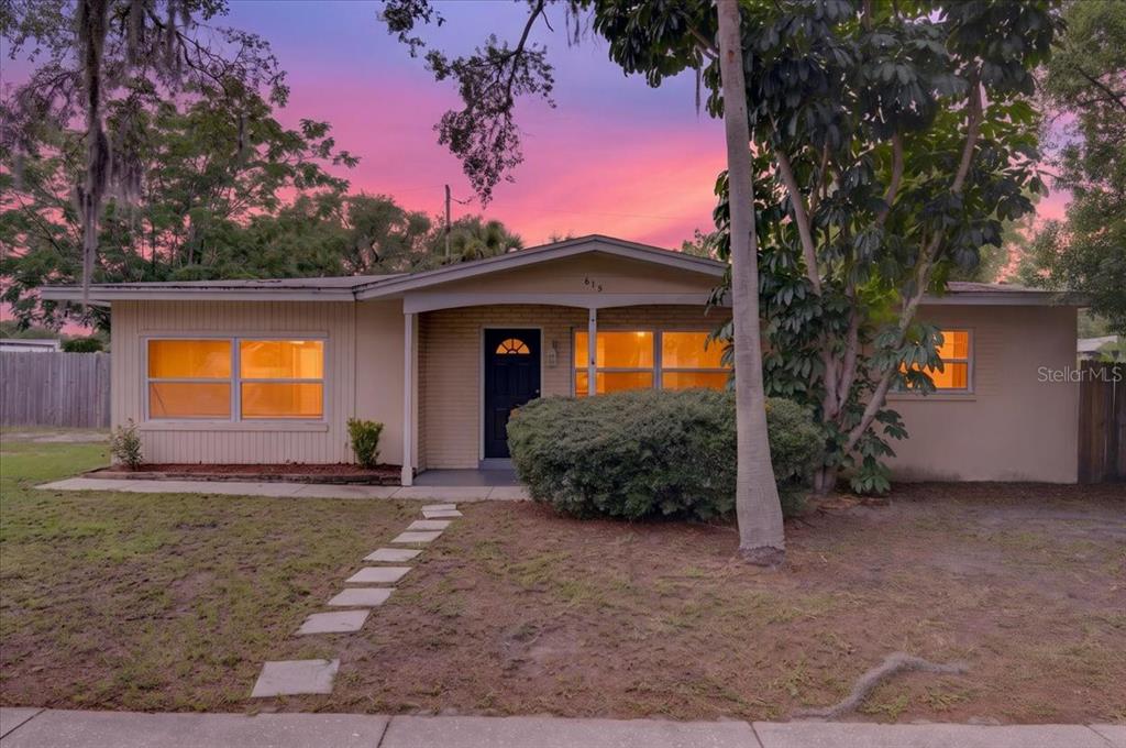 A single-story house with a beige exterior, a front porch, and a stone walkway — 615 5TH AVENUE N, SAFETY HARBOR, FL