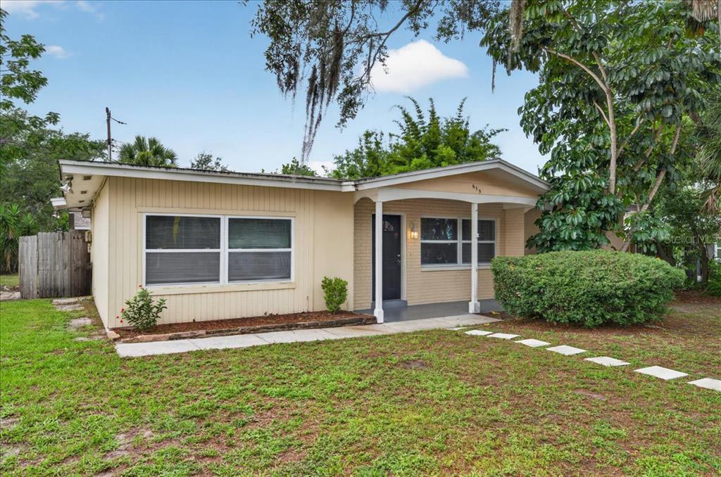 A single-story house with beige siding and brick accents features a covered front porch — 615 5TH AVENUE N, SAFETY HARBOR, FL
