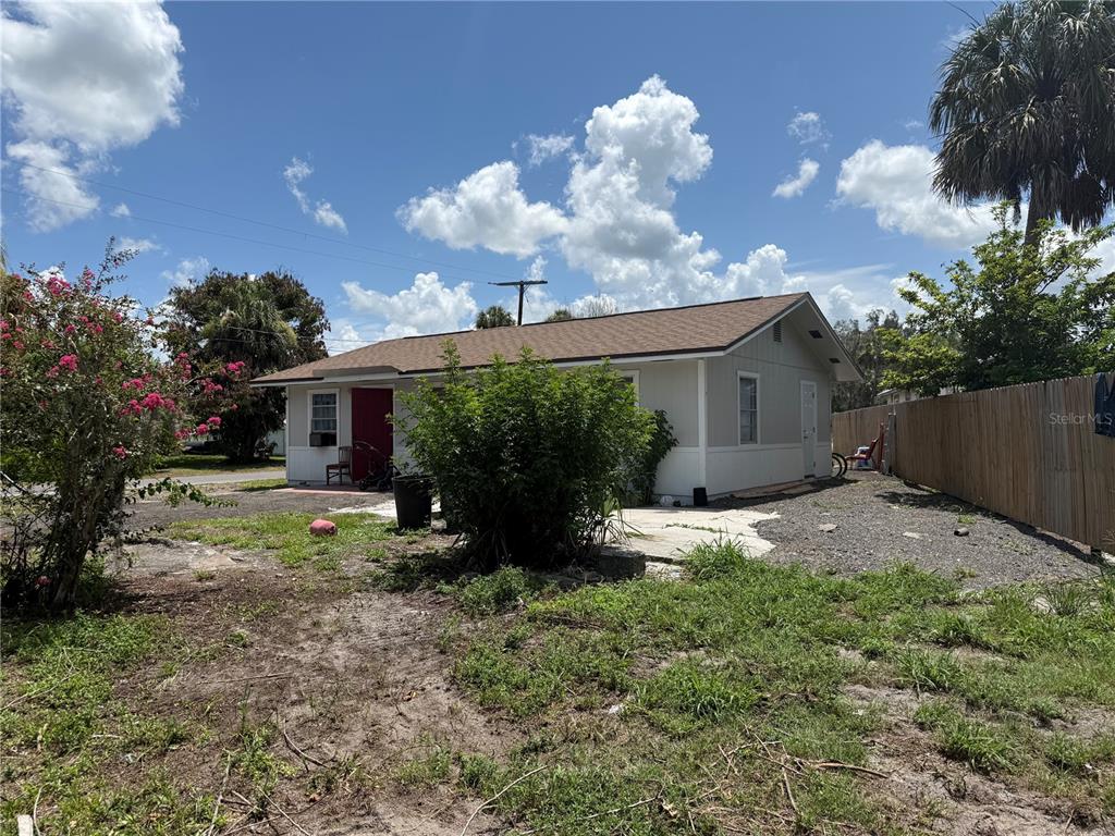 A single-story house with a red door, light siding, and a brown shingled roof — 326 E WHIDDEN STREET, ARCADIA, FL