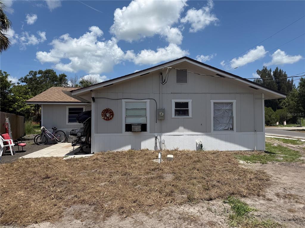The exterior of a single-story house features light-colored siding, a concrete patio, and a yard — 326 E WHIDDEN STREET, ARCADIA, FL
