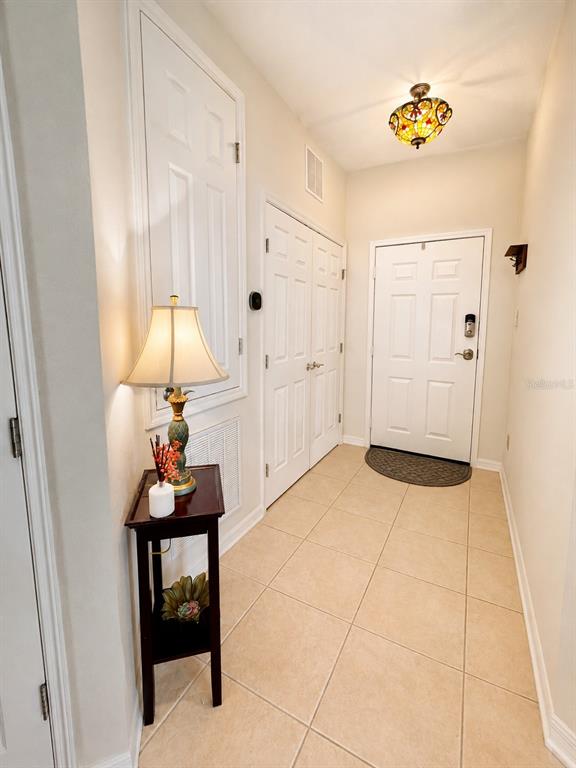 An entryway features tile flooring, a small side table with a lamp, and two doors — 1357 VENEZIA COURT UNIT 303, DAVENPORT, FL