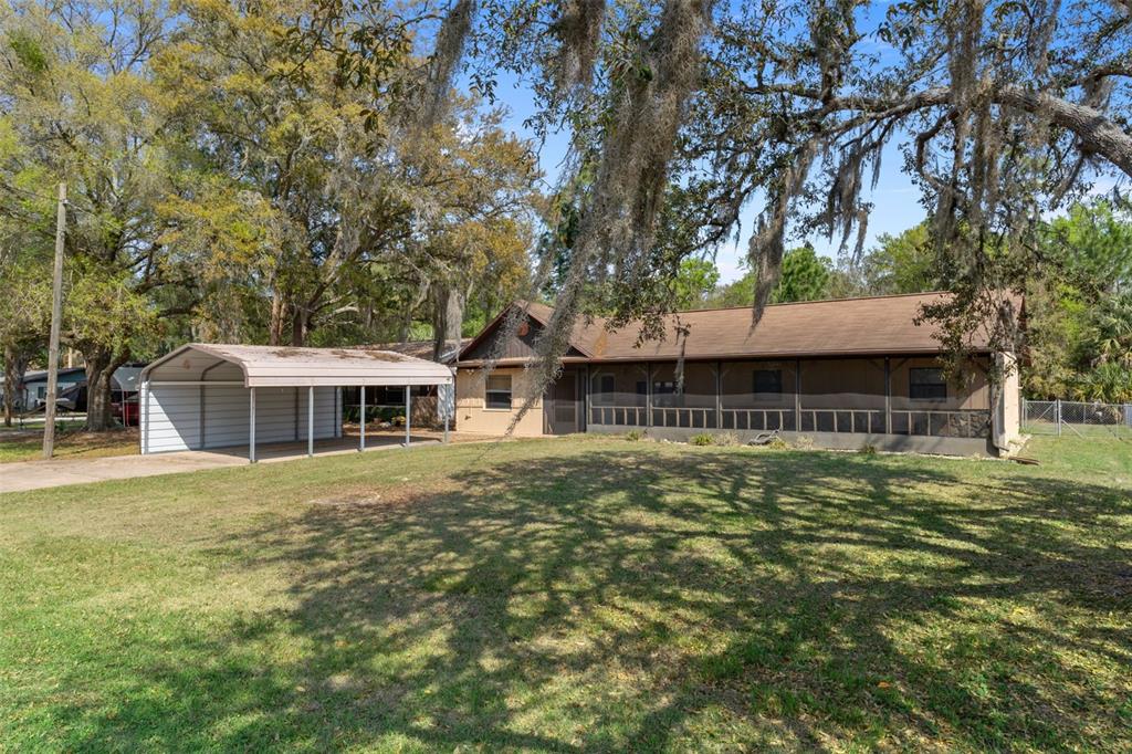 A screened-in porch features a tiled floor, a ceiling fan, and a wooden porch swing — 7095 W GREENWOOD LANE, CRYSTAL RIVER, FL