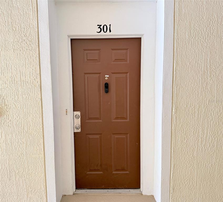 A tiled hallway leads to an arched doorway opening into a kitchen area — 3190 DANTE DRIVE UNIT 301, ORLANDO, FL