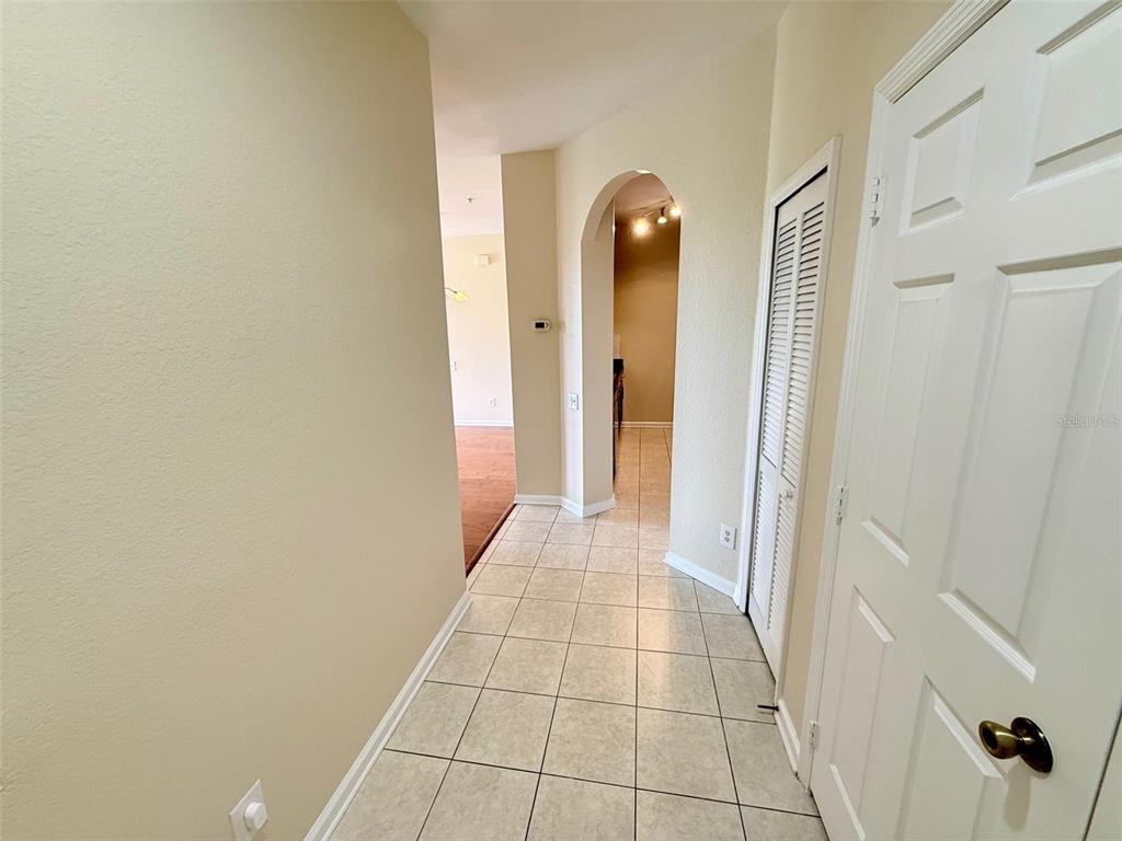 An entryway features tiled flooring, a white front door, and two sets of closet doors — 3190 DANTE DRIVE UNIT 301, ORLANDO, FL