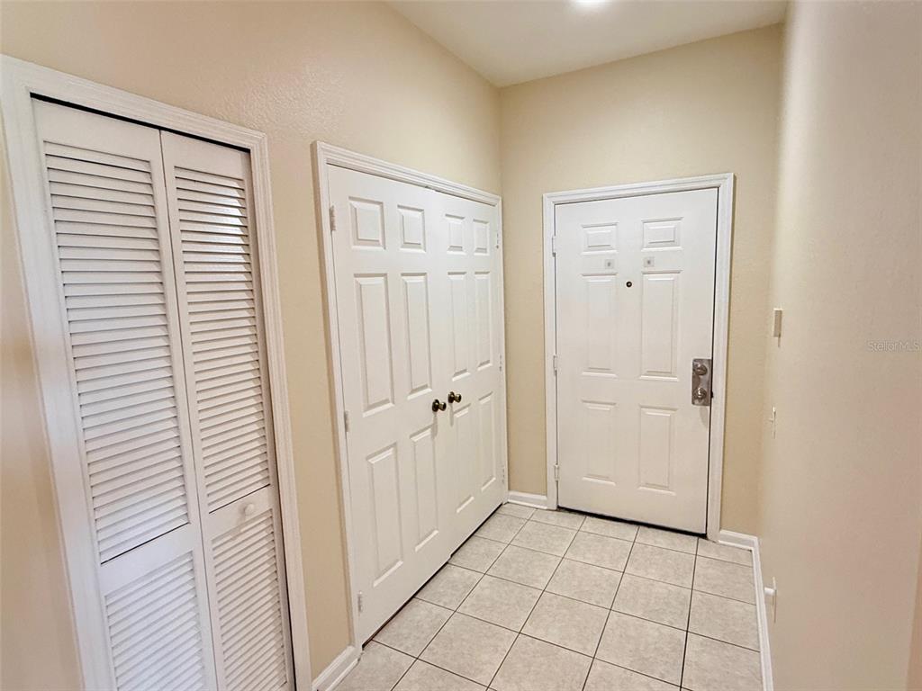 A tiled entryway leads to a kitchen through an archway and a wood-floored living area — 3190 DANTE DRIVE UNIT 301, ORLANDO, FL