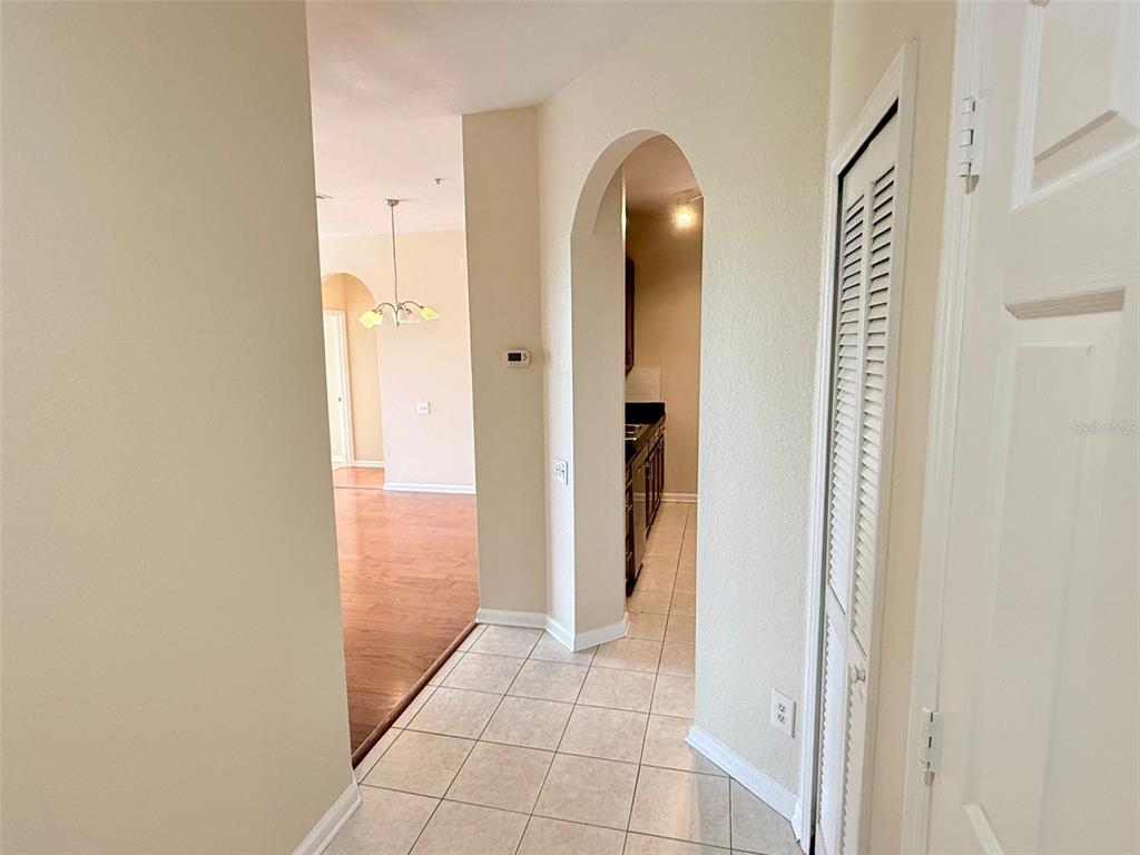 A kitchen features dark countertops, wood cabinets, a double sink, and a pass-through window — 3190 DANTE DRIVE UNIT 301, ORLANDO, FL