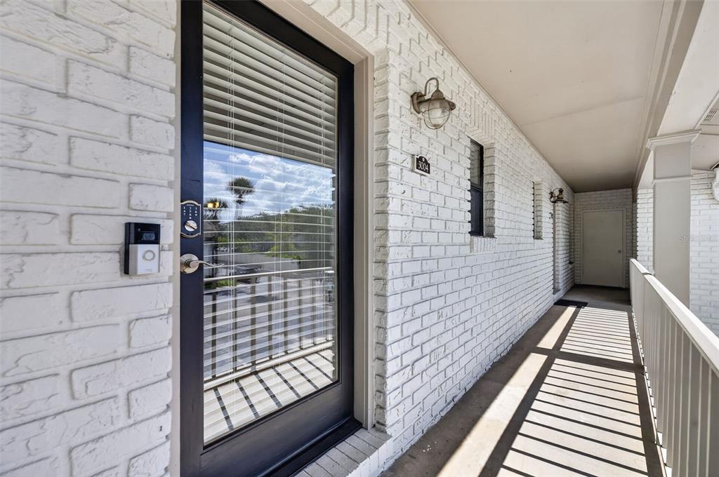 A two-story white brick apartment building with a palm tree and a numbered entrance — 3004 PLAZA TERRACE DRIVE UNIT 3004, ORLANDO, FL