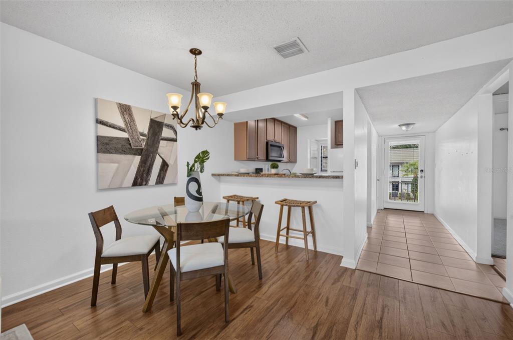 A view from a tiled entryway looking into a wood-floored living area and a kitchen — 3004 PLAZA TERRACE DRIVE UNIT 3004, ORLANDO, FL