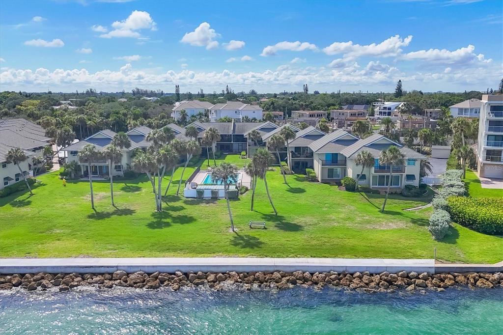 A sign for Sea Village stands in a landscaped area with palm trees and pavers — 4660 OCEAN BOULEVARD UNIT Q2, SARASOTA, FL
