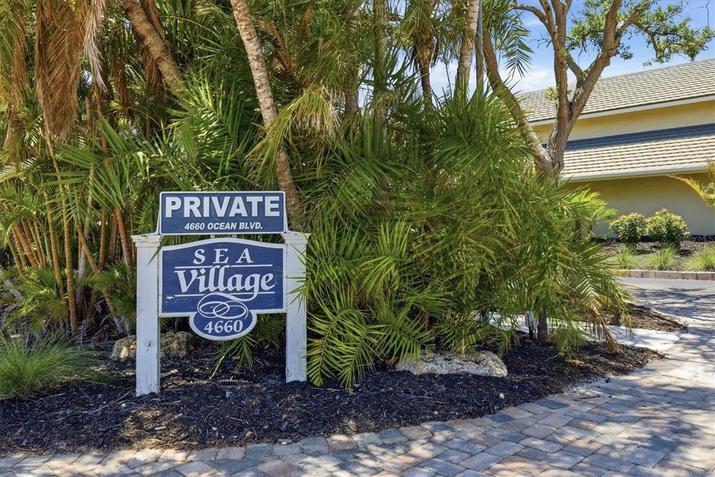 An aerial view shows a coastal condominium complex with multiple buildings, swimming pools, and parking — 4660 OCEAN BOULEVARD UNIT Q2, SARASOTA, FL