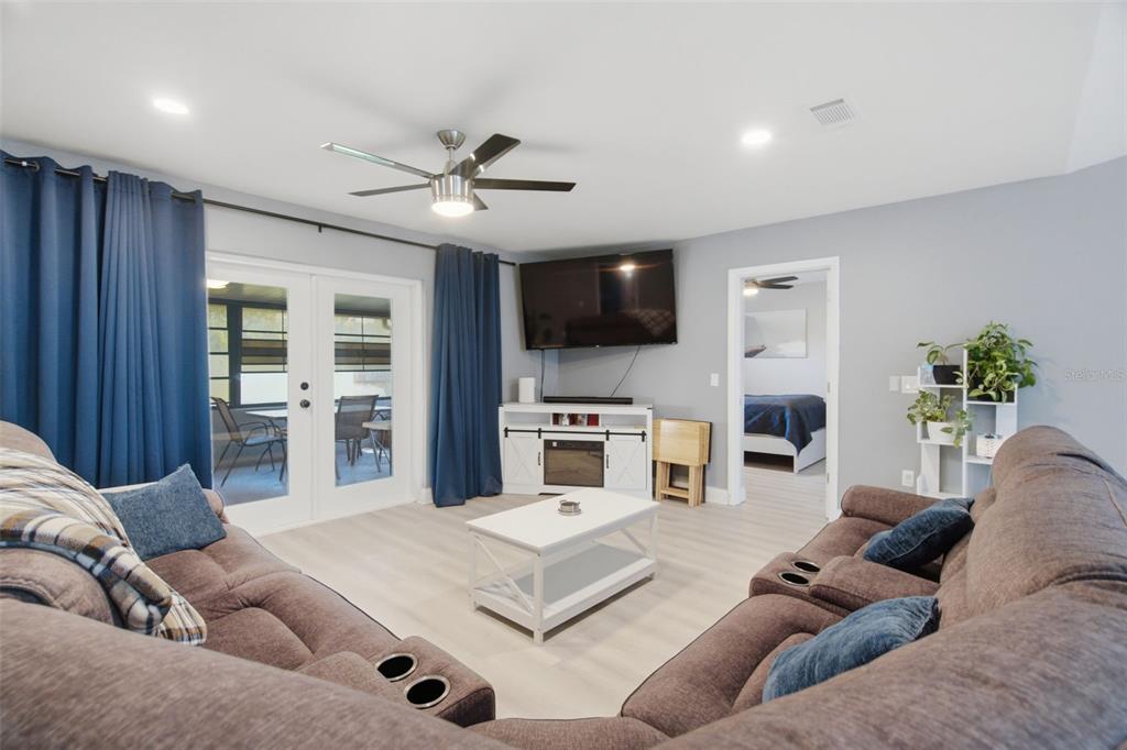 A modern kitchen features a white island with four gray stools and dark gray walls — 7907 DEER FOOT DRIVE, NEW PORT RICHEY, FL