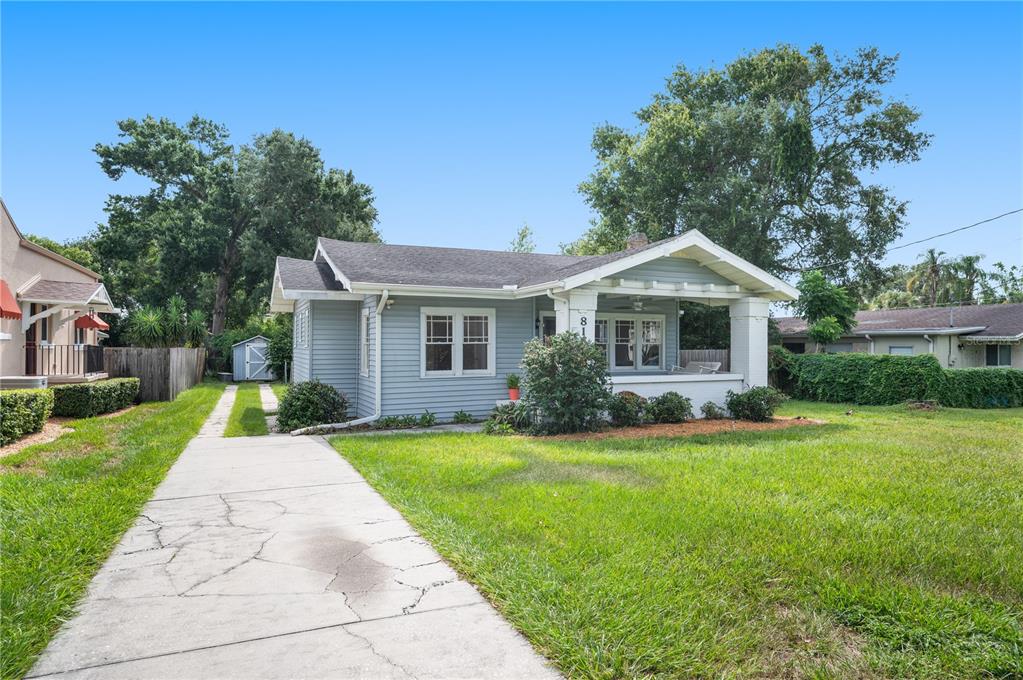 A light blue single-story house features a front porch, a concrete driveway, and a shed — 816 S INGRAHAM AVENUE, LAKELAND, FL