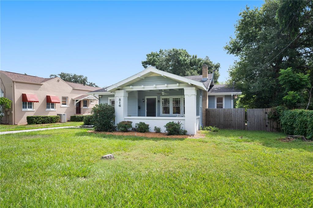 A light blue bungalow with a front porch and white columns sits on a grassy lot — 816 S INGRAHAM AVENUE, LAKELAND, FL