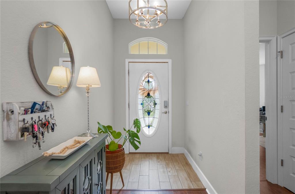A bright entryway features a white door with a stained-glass oval insert and wood-look flooring — 3271 N BURROUGHS PATH, BEVERLY HILLS, FL