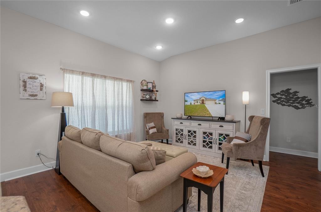 A living room features a beige sofa, two armchairs, a television console, and hardwood floors — 3271 N BURROUGHS PATH, BEVERLY HILLS, FL