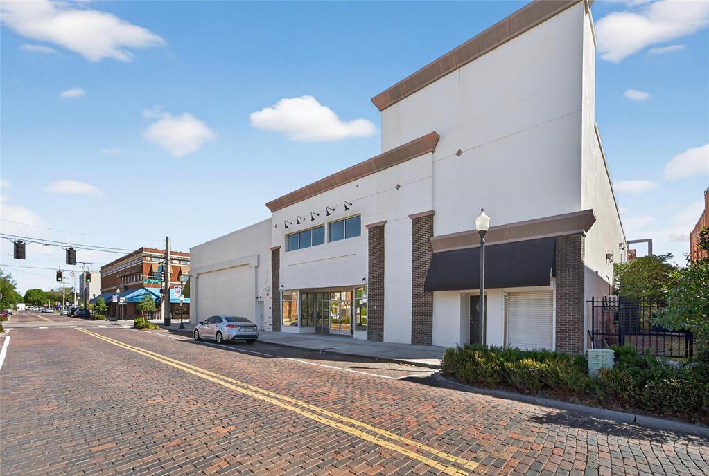 A two-story commercial building with a brick-paved street in the foreground — 106 N EVERS STREET, PLANT CITY, FL