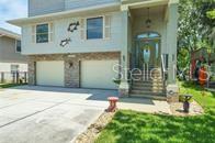 A two-story house with a two-car garage, stone accents, and a covered front entryway — 5361 CIRCLE DRIVE, WEEKI WACHEE, FL