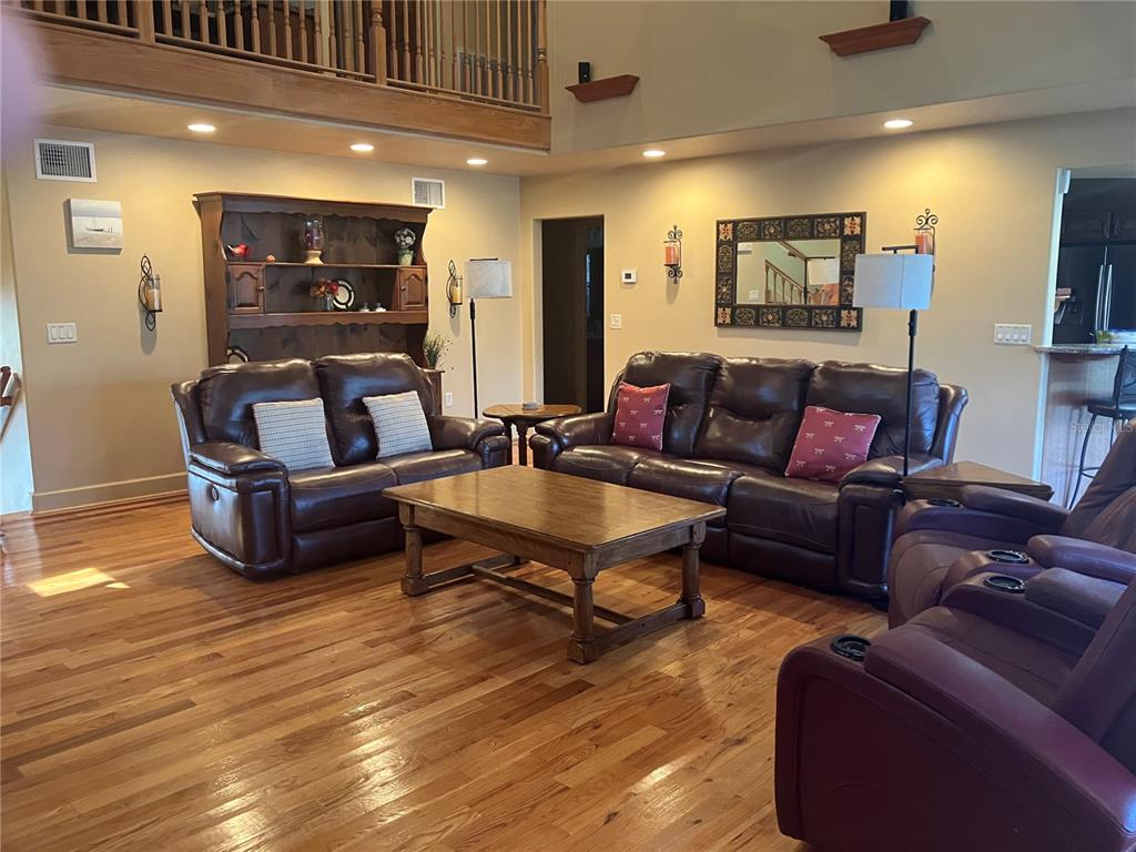 A living room features hardwood floors, leather furniture, a wooden coffee table, and a hutch — 5361 CIRCLE DRIVE, WEEKI WACHEE, FL