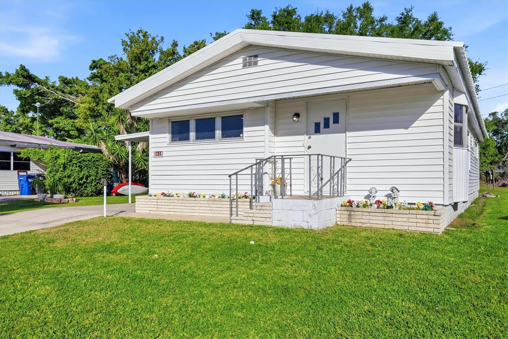 A white, single-story house with horizontal siding and a front porch with metal railings — 1419 41ST AVENUE E, ELLENTON, FL