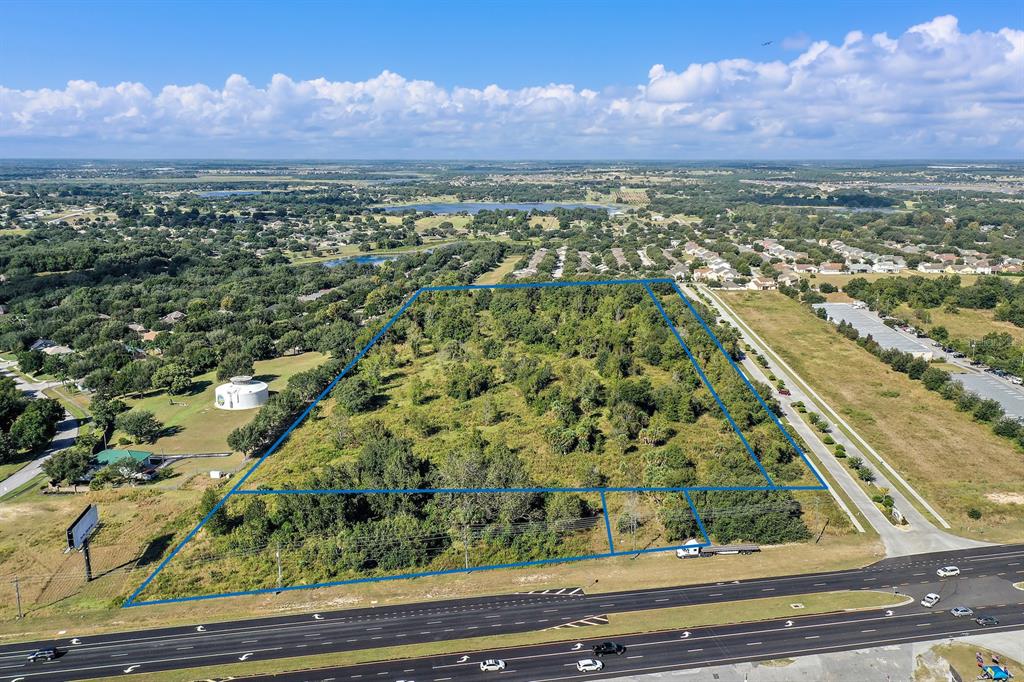 An aerial view shows a large, wooded, rectangular plot of land bordered by a highway — 17545 US HWY 27, MINNEOLA, FL
