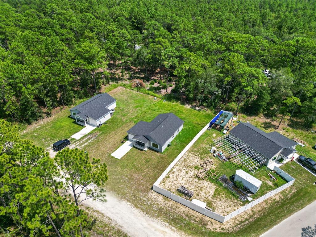 An aerial view shows three houses on large lots surrounded by dense forest — 15934 SW 41ST STREET ROAD, OCALA, FL