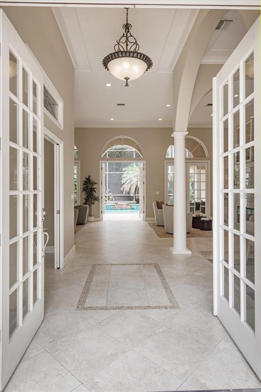 An entryway with tile flooring leads to an open living area overlooking a swimming pool — 4965 SHORELINE CIRCLE, SANFORD, FL