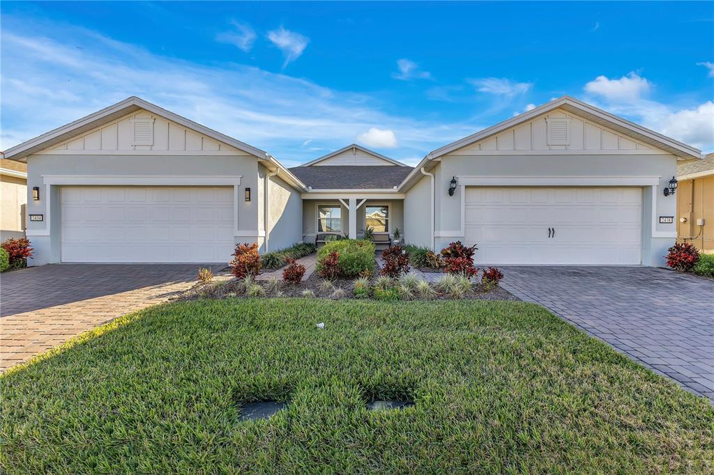 A single-story house with two garage doors, a central entryway, and a paved driveway — 2434 N CLIFF WAY, ST CLOUD, FL