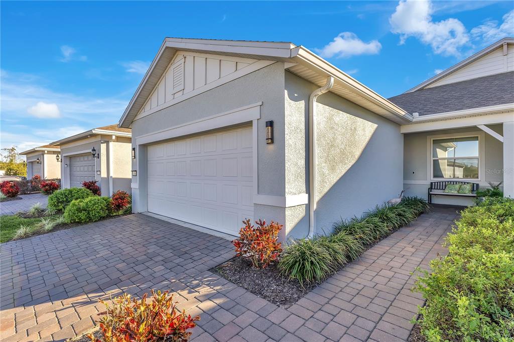 A light-colored house exterior features a paved driveway, a garage, and a landscaped walkway — 2434 N CLIFF WAY, ST CLOUD, FL
