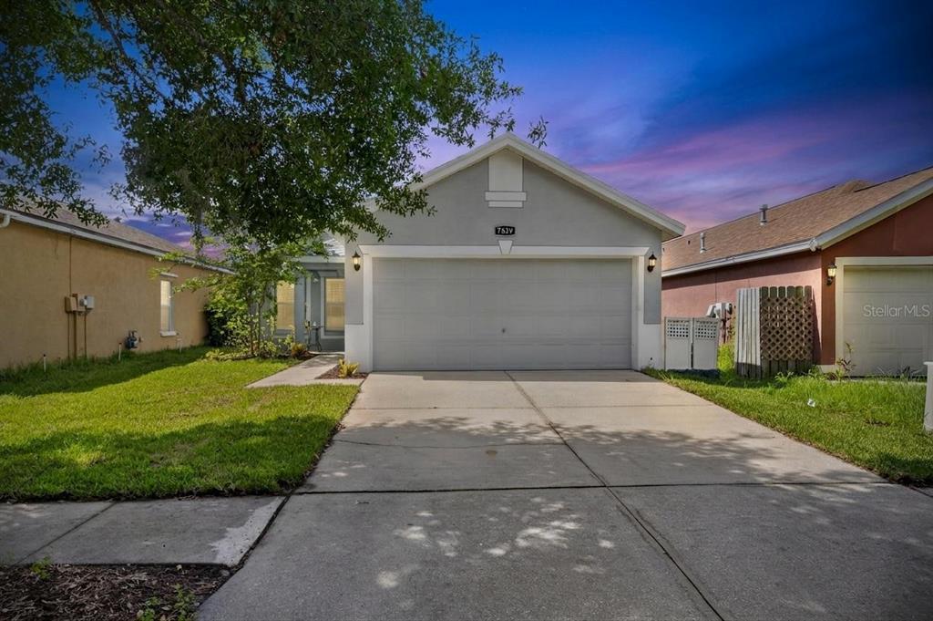A gray single-story house with a two-car garage and a concrete driveway — 7629 DEVONBRIDGE GARDEN WAY, APOLLO BEACH, FL