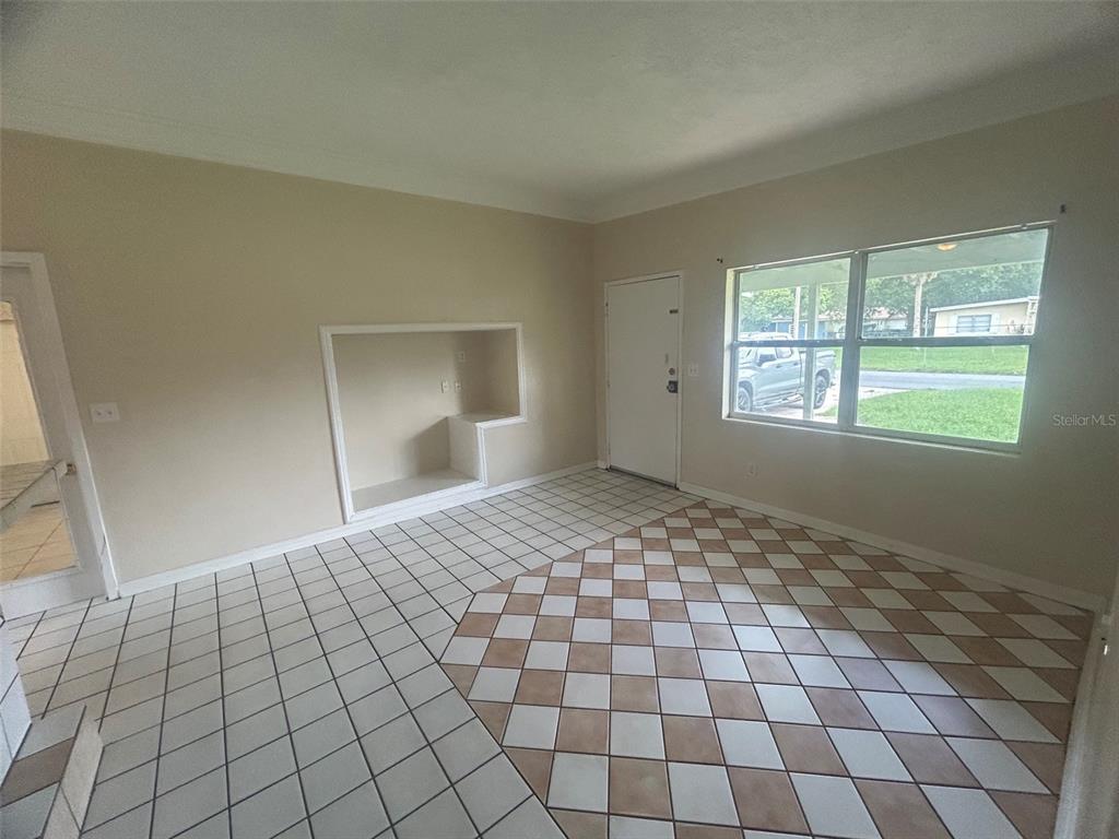 A room with beige walls, a white built-in niche, and a checkered tile floor — 127 COUNTRY CLUB DRIVE, SANFORD, FL