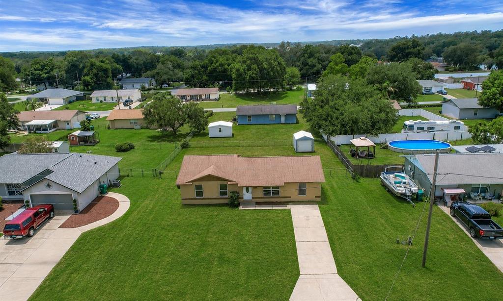 An aerial view shows a tan house with a brown roof and a large lawn — 1229 PADGETT CIRCLE, LADY LAKE, FL