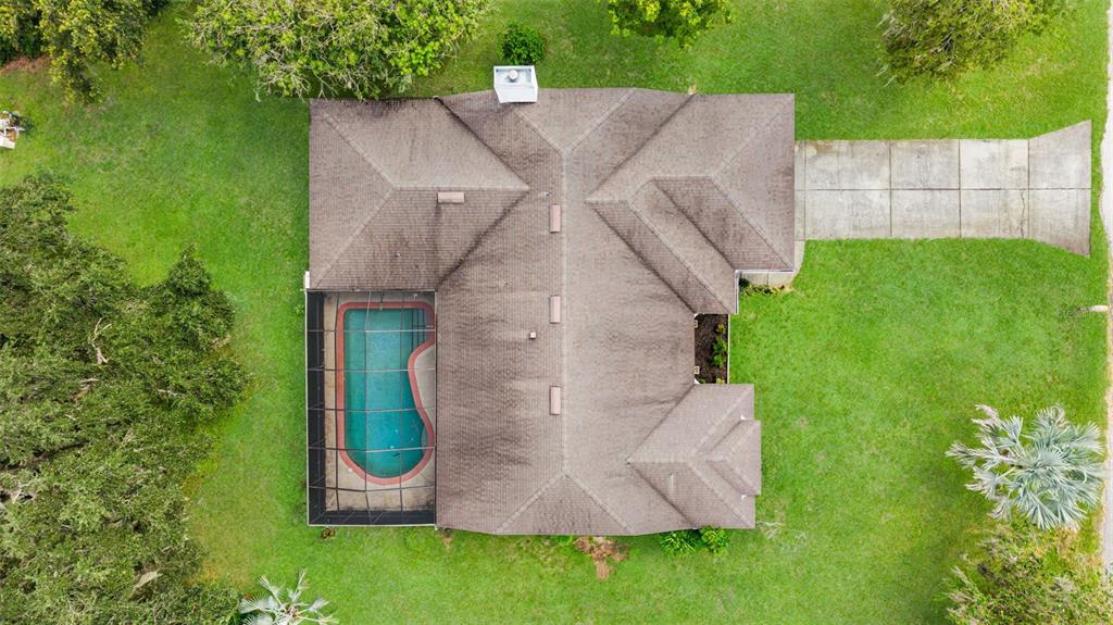 An aerial view shows a house with a shingled roof, a screened pool, and driveway — 930 ALBRITTON WAY, LAKE WALES, FL
