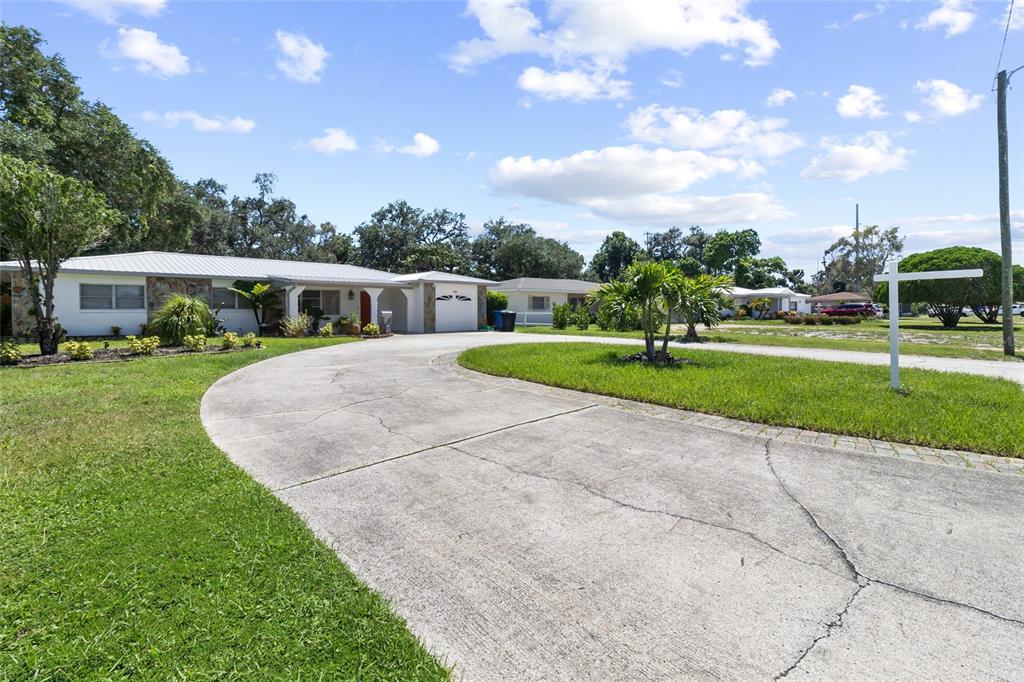 A single-story house with a curved concrete driveway and a large front lawn — 3000 PONCE DE LEON WAY S, ST PETERSBURG, FL