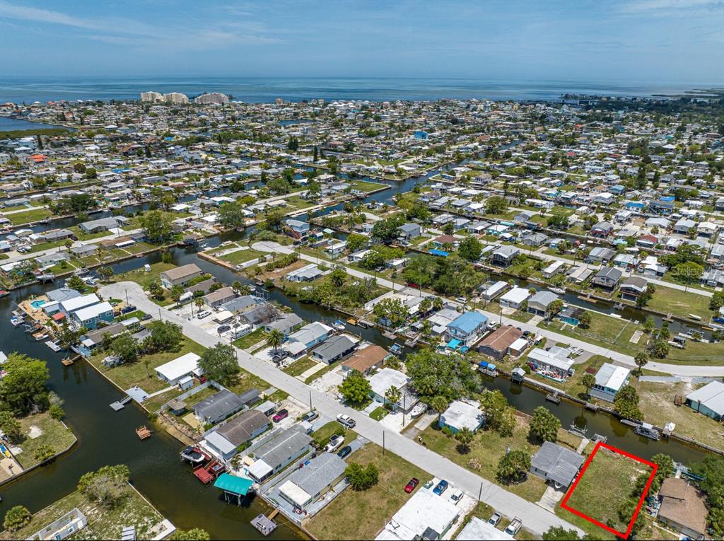An aerial view shows a vacant residential lot outlined in red within a waterfront neighborhood — 6845 SANDERLING LANE, HUDSON, FL
