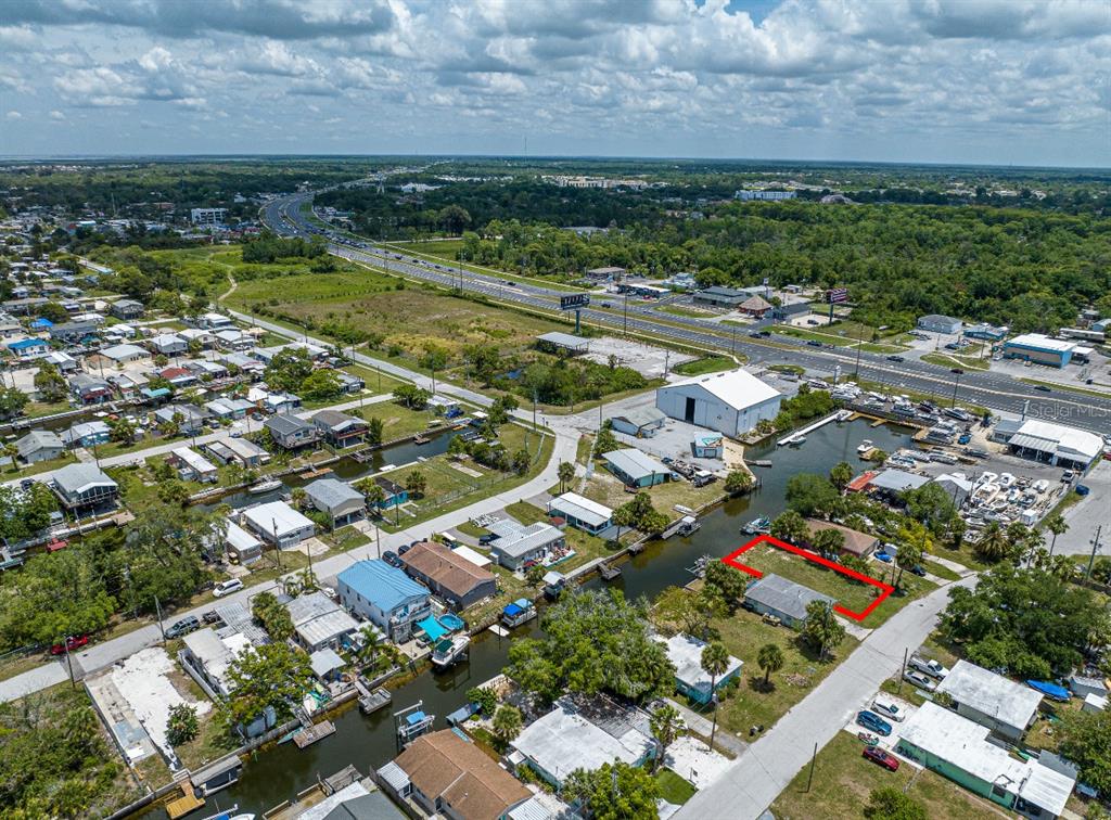 An aerial view shows a residential property with a red outline next to a canal — 6845 SANDERLING LANE, HUDSON, FL
