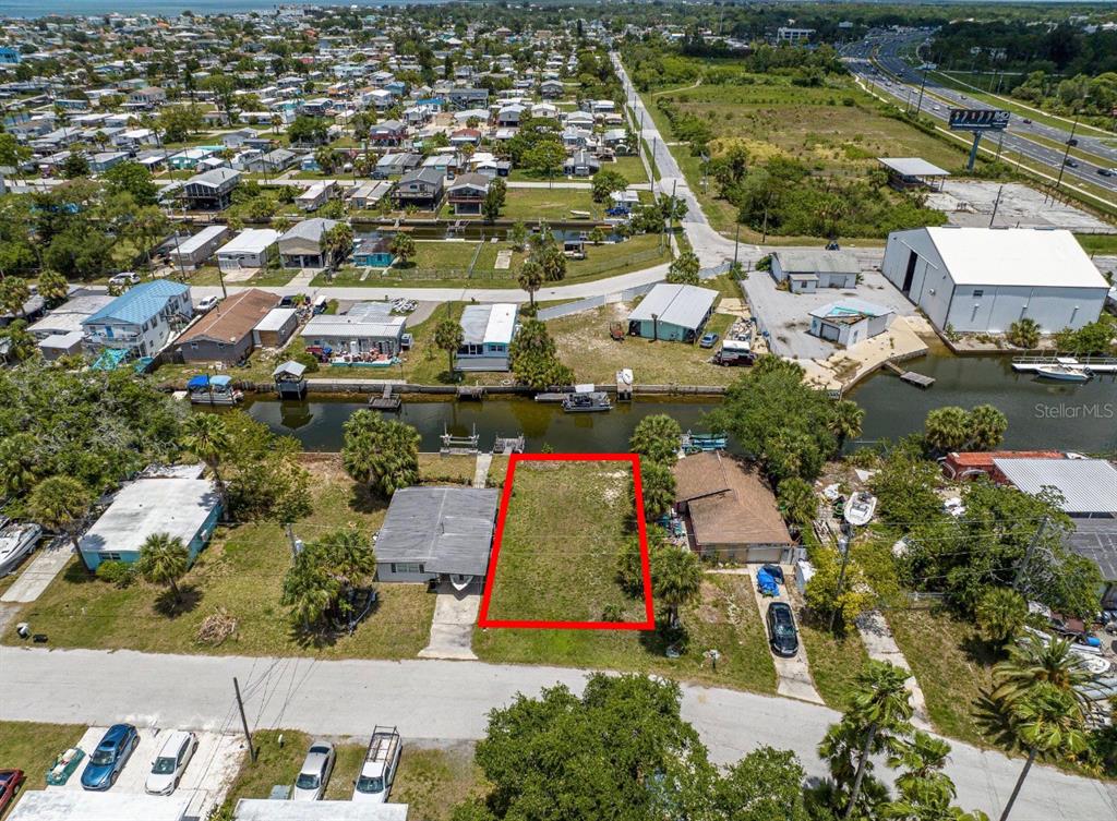 An aerial view shows a vacant rectangular lot outlined in red between two houses — 6845 SANDERLING LANE, HUDSON, FL