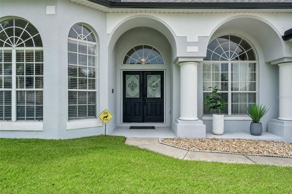 The exterior of a house features a double front door, arched windows, and columns — 13163 LAKESHORE GROVE DRIVE, WINTER GARDEN, FL