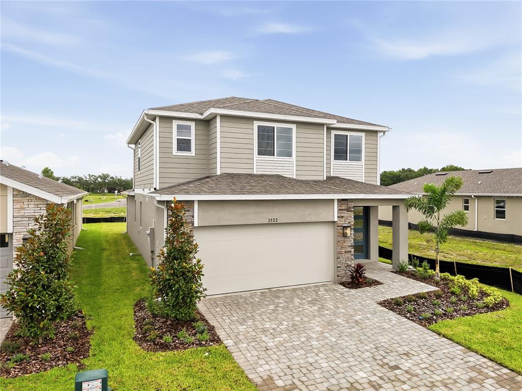 A two-story house with a stone-accented garage, gray siding, and a paved driveway — 2322 ANDERS DRIVE, PARRISH, FL
