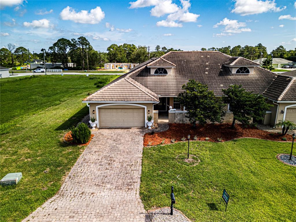 An aerial view of a single-story house with a tiled roof and a paved driveway — 6938 CECILIA AVENUE, SEBRING, FL