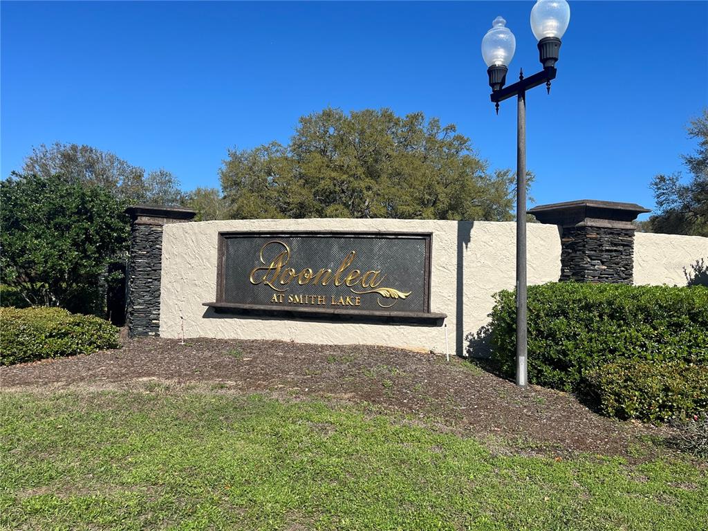A stone and stucco entrance sign for Loonlea at Smith Lake stands outdoors — 000 SE 118TH LANE, BELLEVIEW, FL