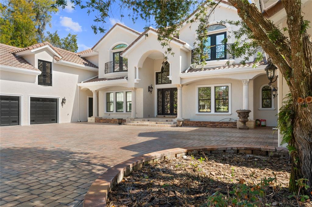 A large two-story stucco house with a paved driveway and a three-car garage — 3409 SE 17TH COURT, OCALA, FL